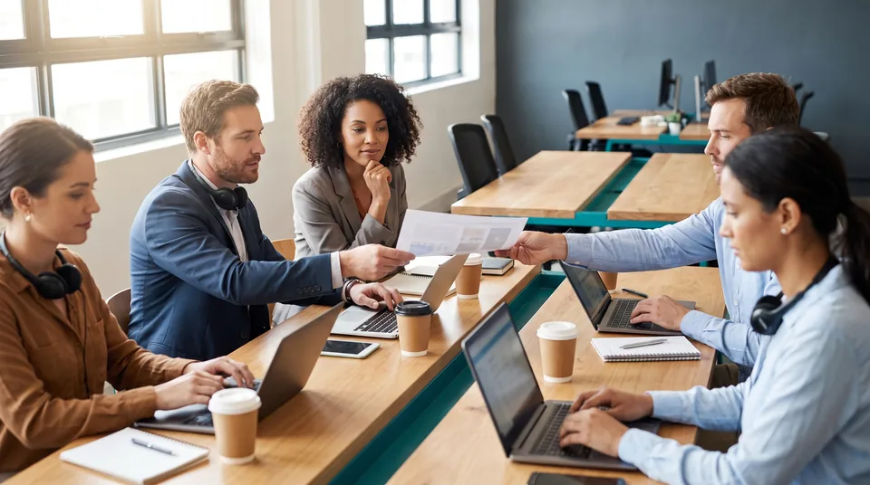 Five sales reps at a shared table working from one prospect list
